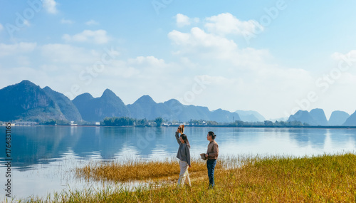 Fotografie Chinese couple enjoying Quyang Lake (Quyanghu)  karst peaks landscape standing o