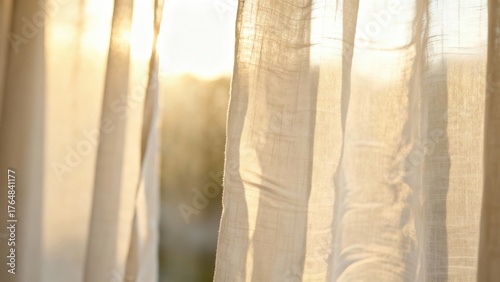 Golden morning sunlight streaming through sheer linen window curtains, creating a warm and peaceful glow.