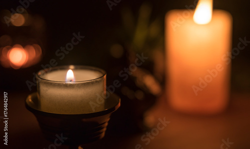 Decoration with candles and other objects in the background. A candle in the foreground.