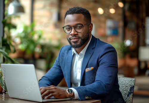 Man in blue suit working on laptop at a table