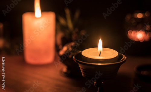 Decoration with candles and other objects in the background. A candle in the foreground.