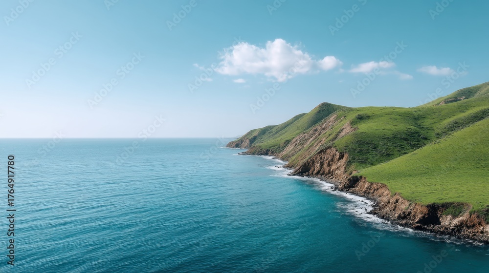 Obraz premium Serene Green Hills Descending to Tranquil Sea Under Bright Sunlight Reflected on Calm Waters