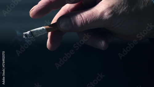 Hand holding smoking cigarette 