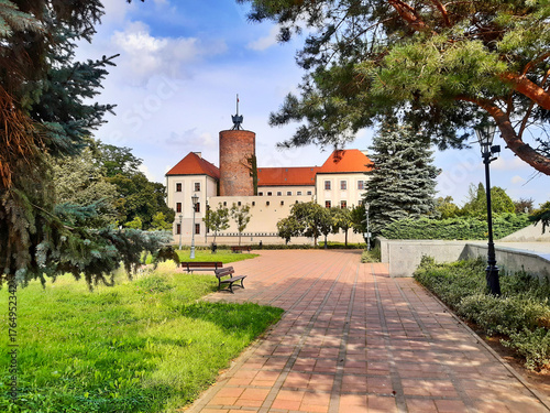 Historic castle Ksiazat Glogowskich with red tiled roofs and lush gardens