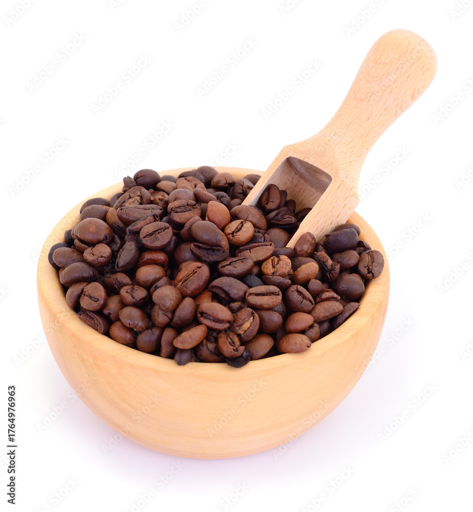 Fototapeta premium Roasted coffee beans in wooden bowl with scoop isolated on white background