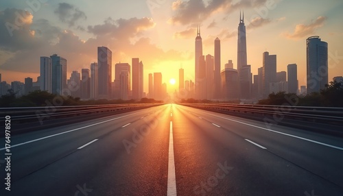 Empty highway approaches modern city skyline at golden sunset. Tall buildings rise against an orange cloud sky. Road reflects bright sun rays into distance. Urban landscape shows growth, future.