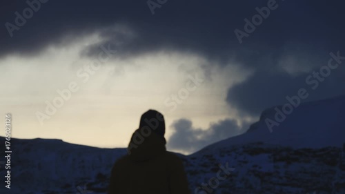 Man stands on the final rock above wild Arctic scenery in Northern Norway, alone with his thoughts