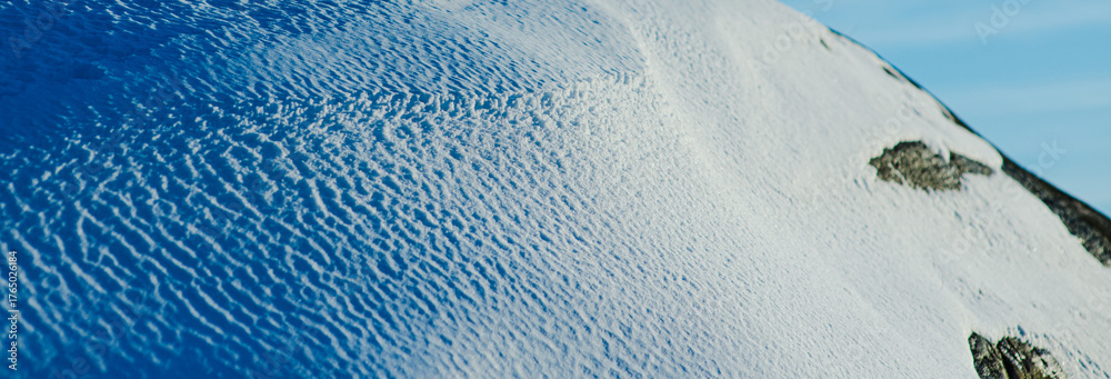 Fototapeta premium Closeup of textured snow surface in winter sunlight.