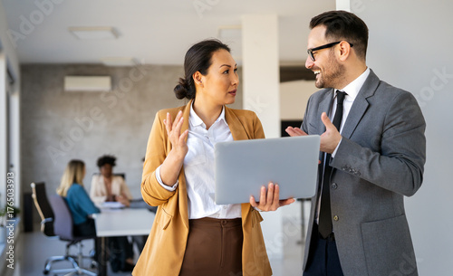 Portrait of successful business people working, talking together in corporate office during work.