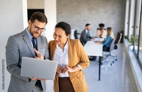 Multicultural professional businesspeople working together on research plan in boardroom.