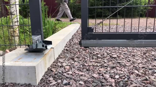 the sliding gate opens, a man with nordic walking