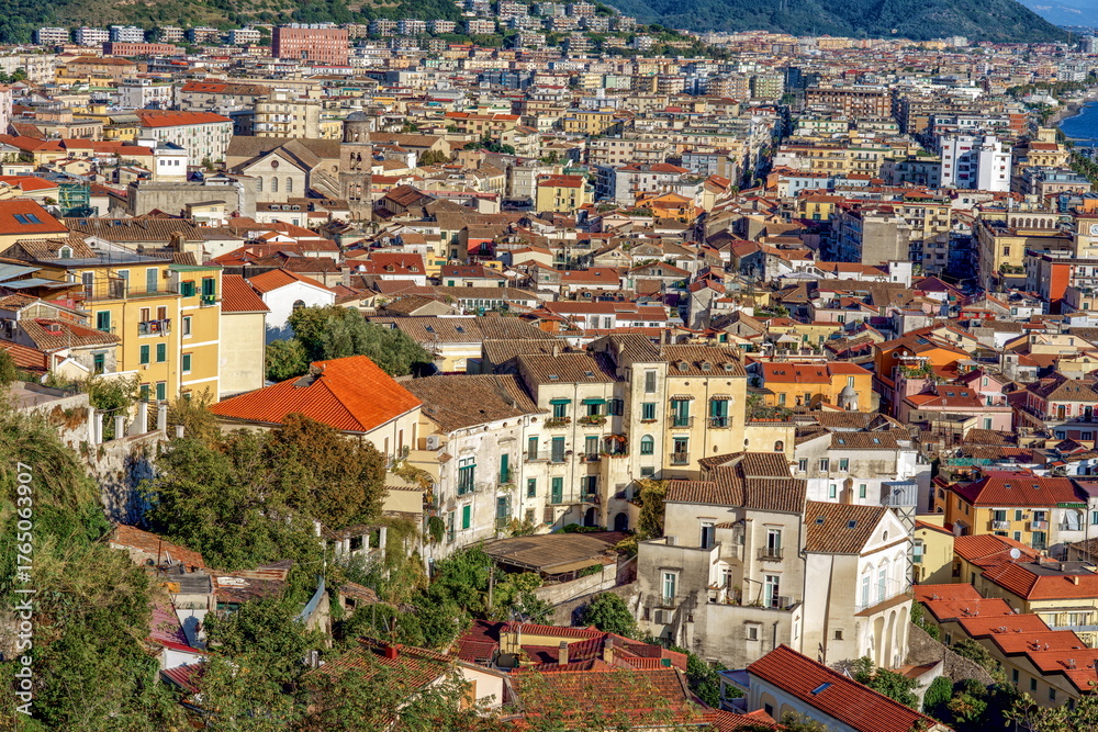 Obraz premium Salerno, Italy. Aerial view of a vibrant urban landscape showcasing colorful buildings terracotta rooftops and lush greenery illustrating the charm of a coastal city environment