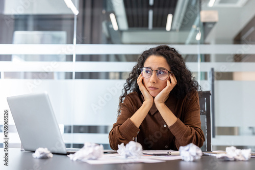Quadro su tela Woman feeling overwhelmed at her office desk, looking frustrated and tired, surr