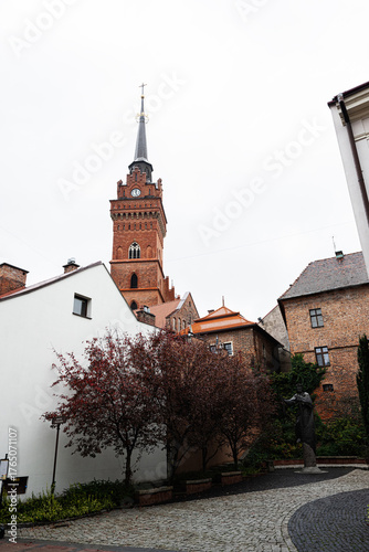 Photos Historic church tower in Tarnow Poland rises over cobblestone street and old tow