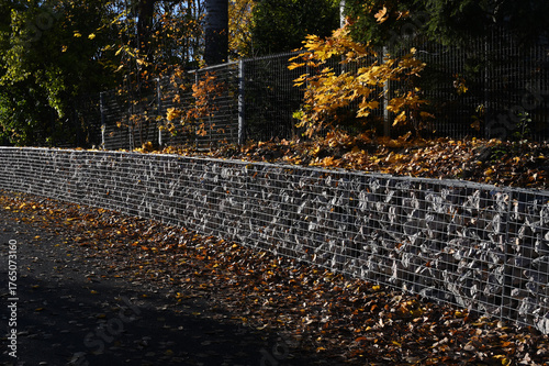 a gabion stone wall lined with a metal fence