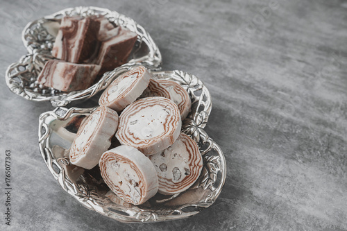 An assortment of oriental halva on a luxurious platter in the shape of two hearts. Round and sharp-angled shape of halva. Copy space.