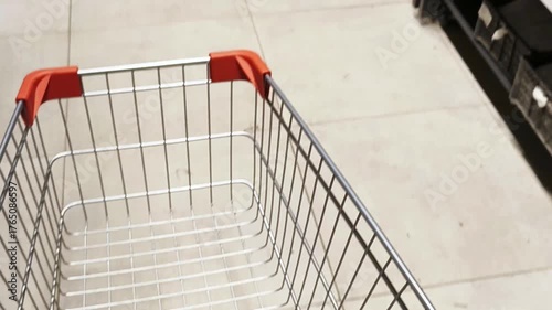 Red shopping cart in the supermarket. Business online retail concept. Closeup