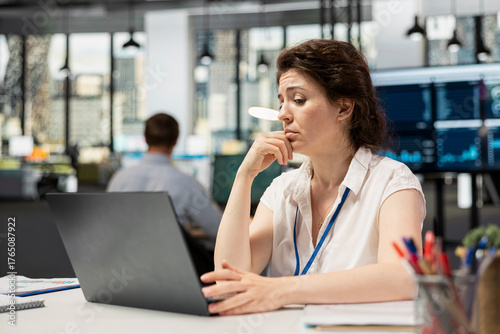 Foto White female manager checking analytics on device, analyzing financial data with puzzled expression about company information