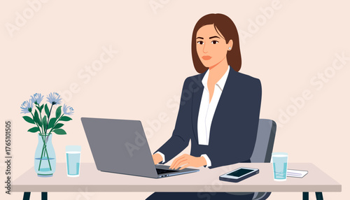 Businesswoman focused at desk with flowers in bright office