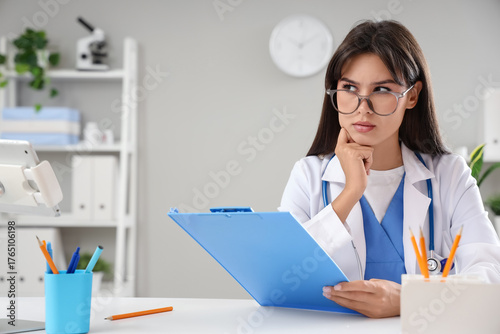 Thoughtful female doctor wi...