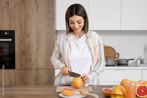 Young woman cutting grapefr...