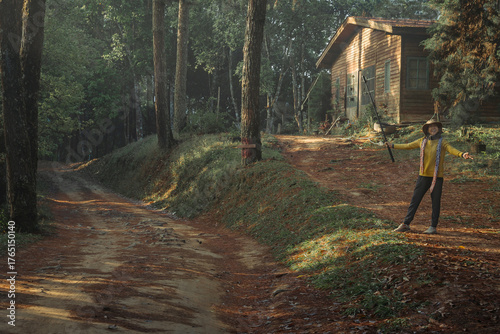 Asian woman traveler is happy with the scenic dirt road through a dense mountain pine forest in San Pa Kia Mt., Chiang Dao, Chiang Mai, Thailand.