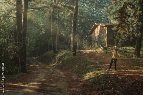 Asian woman traveler is happy with the scenic dirt road through a dense mountain pine forest in San Pa Kia Mt., Chiang Dao, Chiang Mai, Thailand.