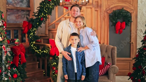 Joyful family celebrates Christmas, creating happy holiday memories. Parents and child smile, enjoying festive decorations and cozy atmosphere. Love and togetherness radiate.