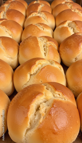 Freshly baked soft bread rolls arranged in a uniform pattern  