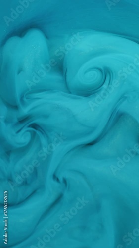 Vertical video. Fume paint. Flow art. Defocused blue cyan color liquid texture in acrylic water mix cloud smog growing on abstract wet background.
