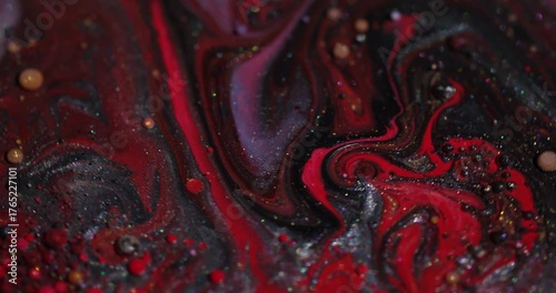 Ink oil mix. Bubble dye. Defocused red purple orange colorful glitter round liquid acrylic droplet floating on abstract art background.