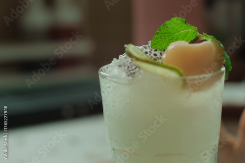 A refreshing iced lychee drink garnished with mint