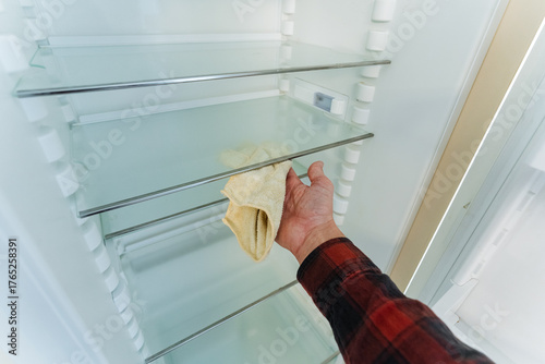 using ecofriendly cloth to systematically clean refrigerator glass shelves naturally and sustainably