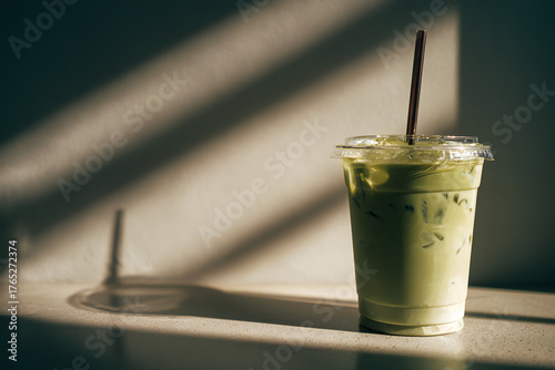 Refreshing Iced Matcha Latte in Clear Plastic Cup with Straw.