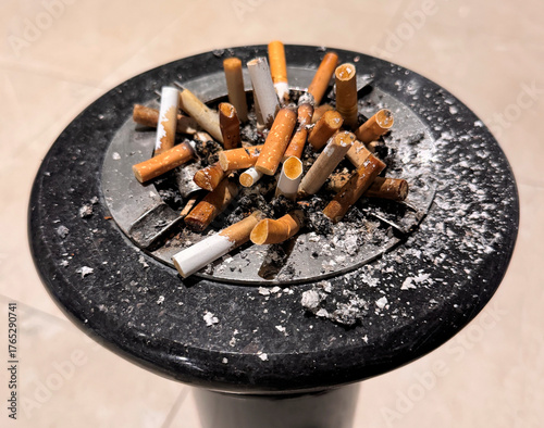 Valokuva ashtray full of cigarette butts with ash everywhere