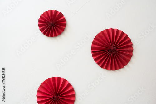 Red origami papers forming circular shapes or fans to decorate a wall with copy space image. Romantic Valentines Day