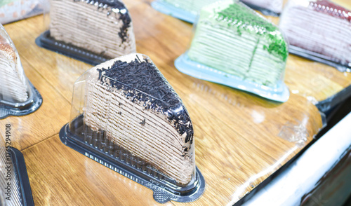 Fotografie A slice of chocolate cake topped with biscuits in a plastic mica container