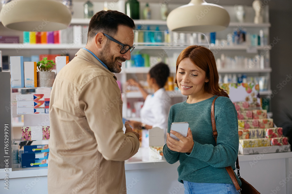Obraz premium Happy couple using smart phone in pharmacy.