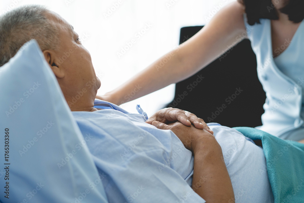 Obraz premium Cheerful asian nurse smiling and covering a blanket to elderly in nursing home.