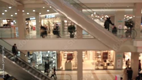 defocused background modern shopping center with many people walking and using escalators, representing consumerism, urban lifestyle, and vibrant atmosphere retail hub.