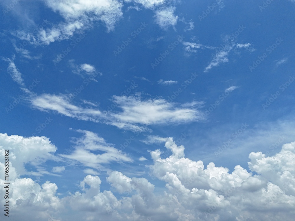 Fototapeta premium Bright blue sky with fluffy white cumulus clouds on a sunny summer day. Drone Photography