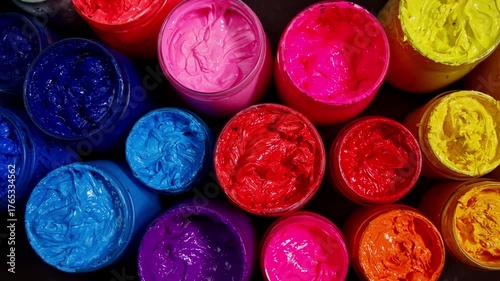  close up look at vivid paint jars arranged in a circular design, highlighting the glossy, tactile texture of pigments ready for creative exploration.