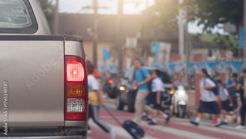 Wallpaper Mural Rear side of car with turn on brake light on the road. Road crossing point with blurry image of students passing by.  Stop to pass for safety reasons. Morning time in the city of Thailand. Torontodigital.ca
