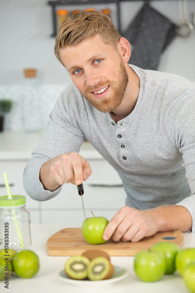 Fototapeta premium young man preparing fresh fruit juice