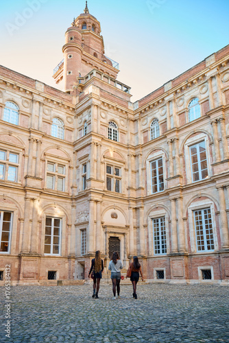 Three women exploring a historic courtyard building in toulouse