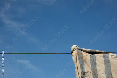A string and a piece of dirty cloth. In the background, a blue sky and clouds.