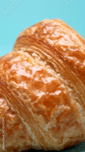 Close Up of Flaky Croissant on Turquoise Background