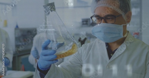 Inspecting scientist wearing lab coat and gloves examining Erlenmeyer flask in lab, copy space
