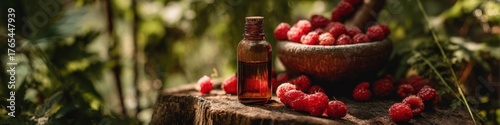 Natural raspberry oil or essence: bottle, fresh berries, and mortar on a stump