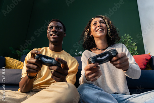 Diverse couple playing video game with controllers smiling